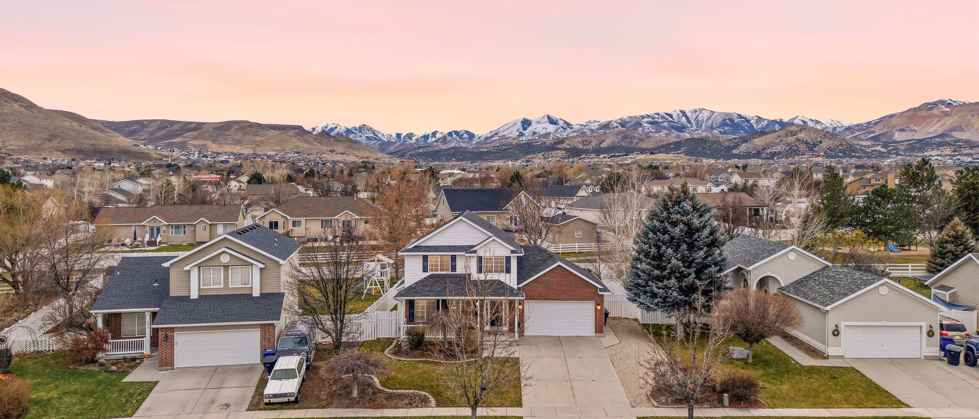 An aerial view of a Salt Lake County neighborhood with mountains beyond